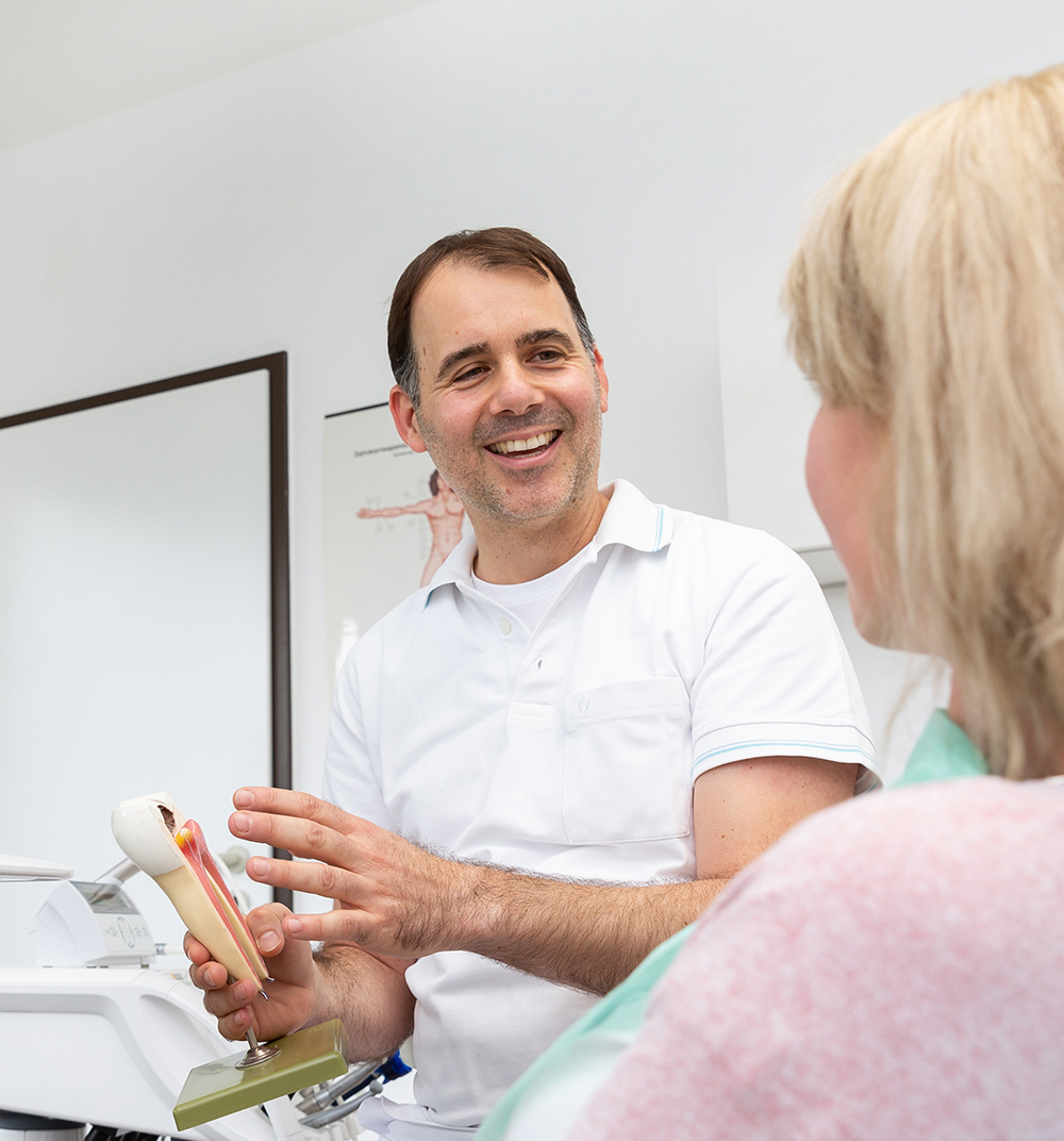 Zahnarzt Dr. Reimer mit Patientin bei der Beratung
